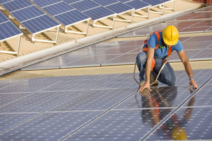 Image of a worker supervising a photovoltaic solar panel installation (ISO 100) . 