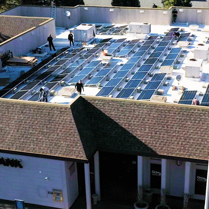 Large group of solar panels installed on rooftop of commercial business